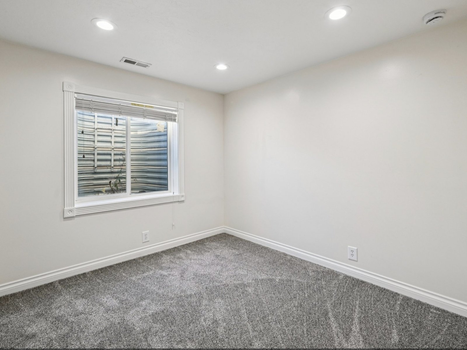 Closed up, baseboard back in and painted. The carpet is the original.
