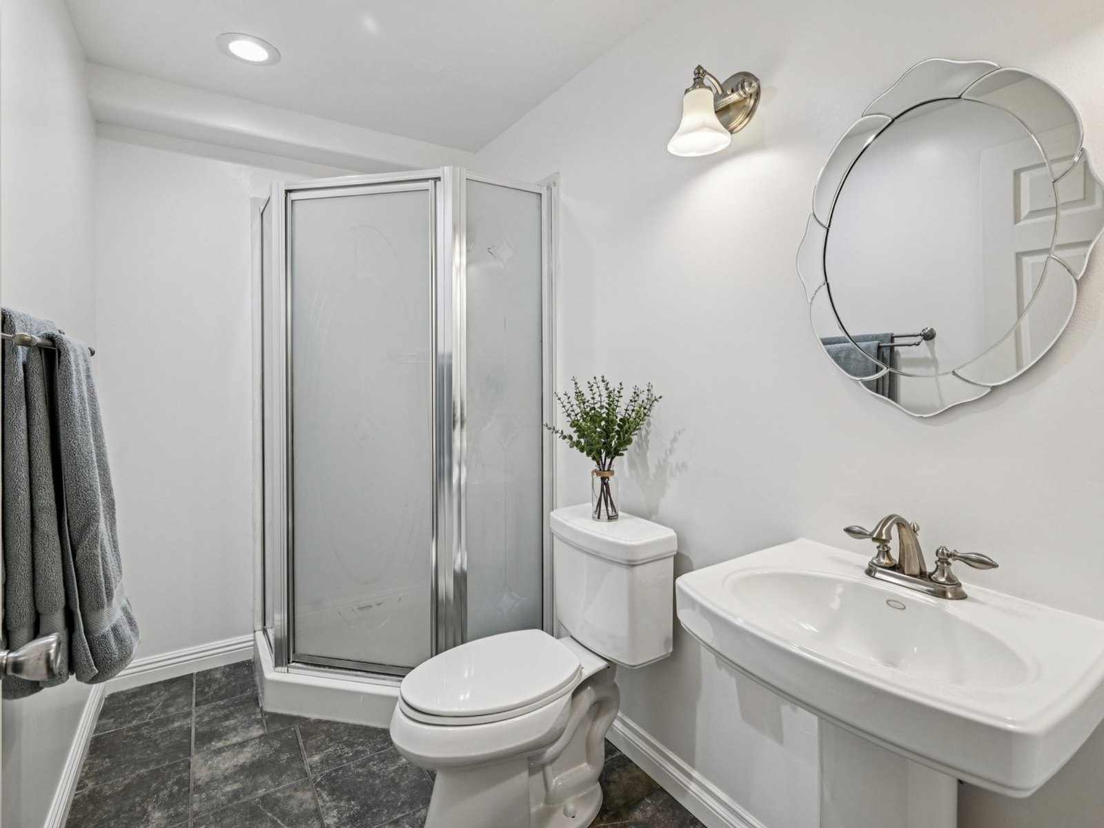 Baseboard put back where it was missing and fresh paint to lighten it. The shower, sink, floor, light and mirror are all the originals.
